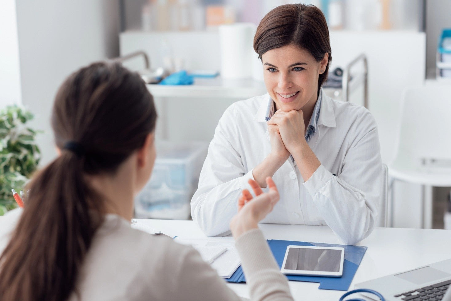 A young woman in consultation with an ExoMind™ TMS therapist.