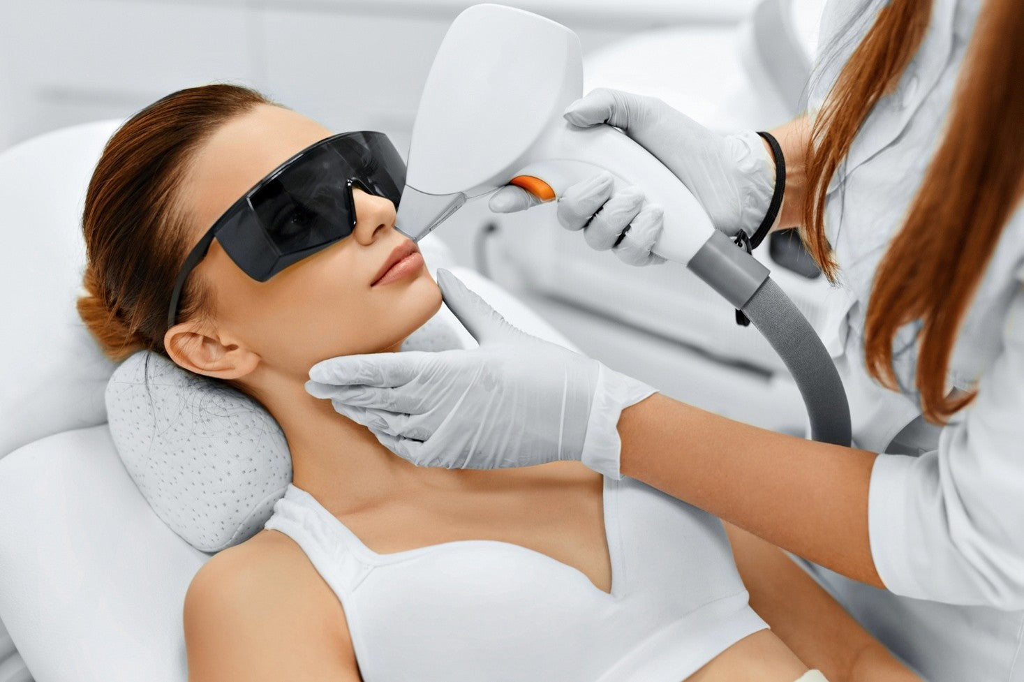 A young woman getting a laser treatment on her face.