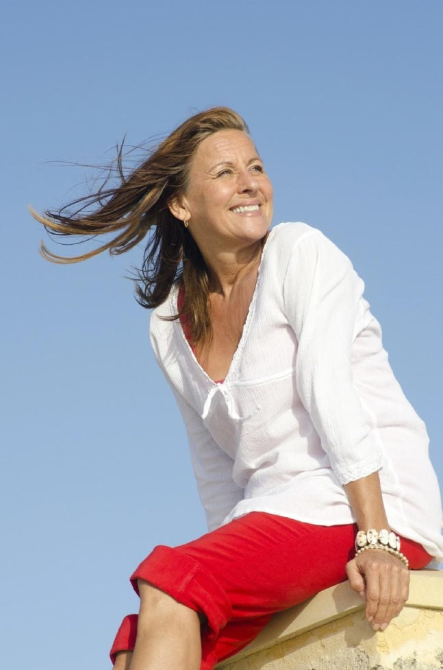 Mature patient enjoying healthy, glowing skin outdoors after facial rejuvenation treatment.